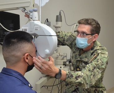 KEY WEST, Fla. (Sept. 14, 2021) - Lt. Cmdr. Joshua Keil, an optometrist at Naval Branch Health Clinic Key West, performs an eye exam on U.S. Coast Guard Petty Officer 3rd Class Thomas Li.  Keil is a native of Palmer, Alaska and holds a doctor of optometry from University of Missouri.  He says, "If we find signs of eye disease early, we can treat it before it gets worse.  That's why everyone needs eye exams, not just those who wear glasses.  It's really about the long-term health of your eyes."  (U.S. Navy photo by Deidre Smith, Naval Hospital Jacksonville/Released).  #FacesofNHJax