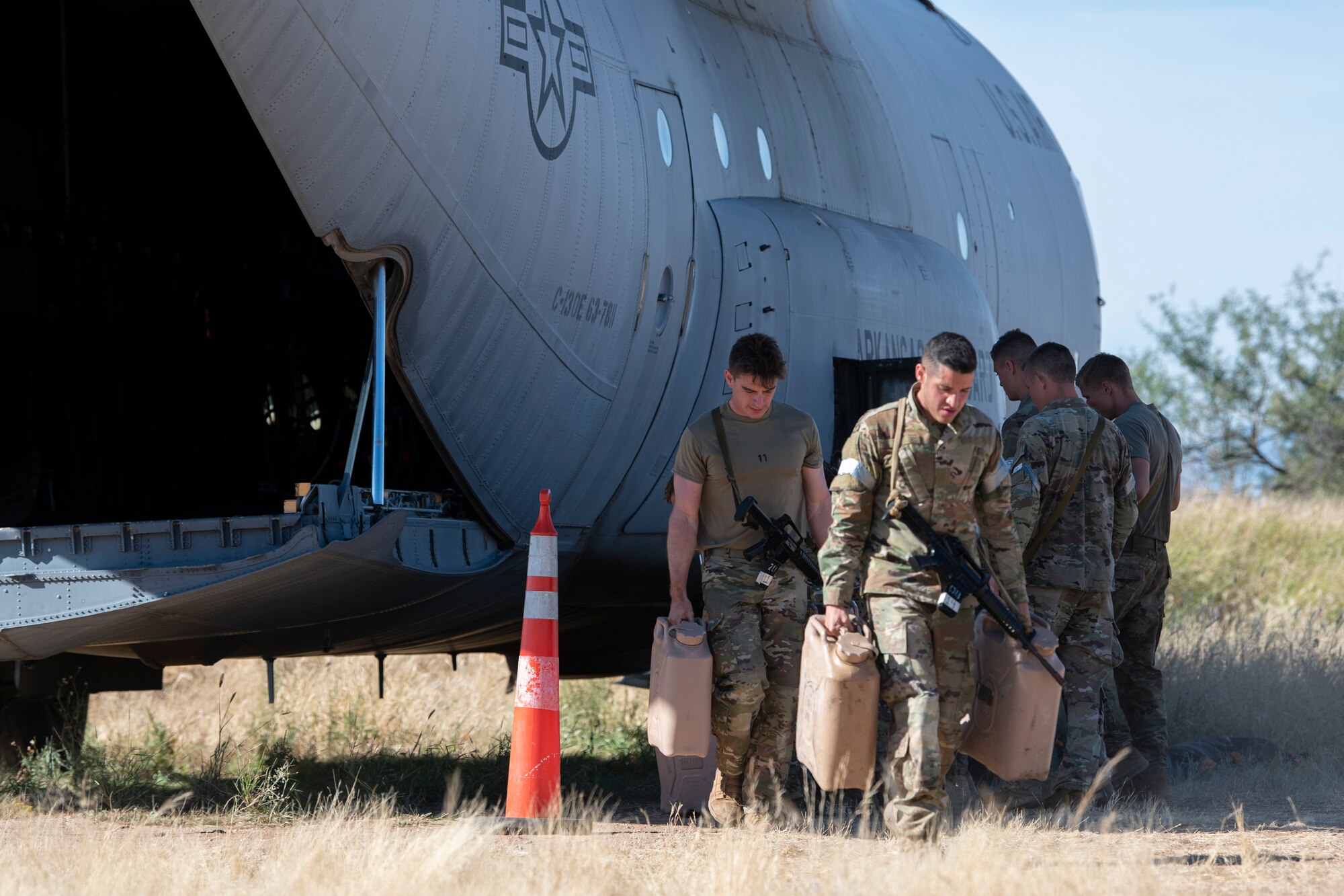 People carry "jerry cans" and walk.