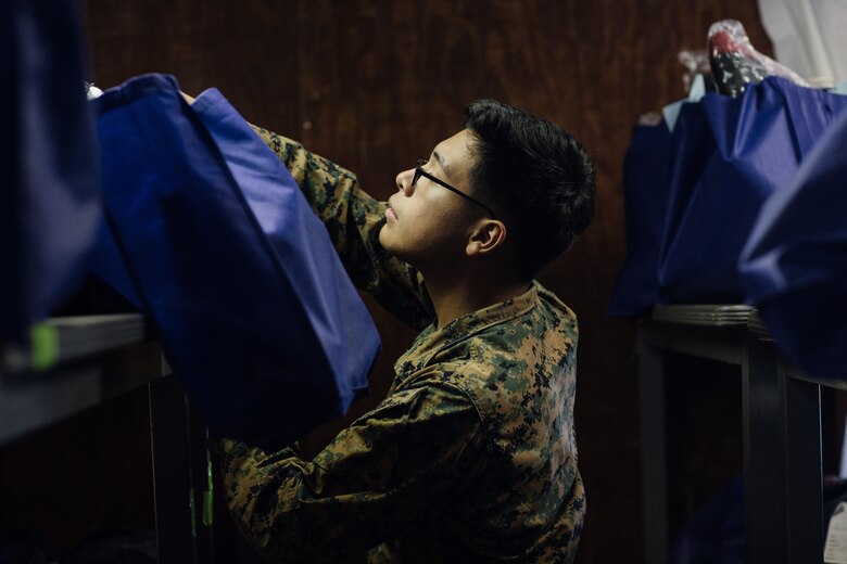 U.S. Marine Corps Lance Cpl. Christian Kangos, an electrician assigned to Task Force Pickett, stocks a shelf with cold weather supplies intended for Afghan guests at Fort Pickett, Virginia, Oct. 23, 2021.