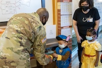 Command Sgt. Maj. Kenneth F. Law, U.S. Army Financial Management Command senior enlisted advisor, gives treat bags to costumed students at a local daycare facility next to the Maj. Gen. Emmett J. Bean Federal Center Oct. 29, 2021. Law, along with Col. Paige M. Jennings, USAFMCOM commander, and Barry W. Hoffman, USAFMCOM deputy to the commander, delivered 100 festive treat bags to students at the center. (U.S. Army photo by Mark R. W. Orders-Woempner)