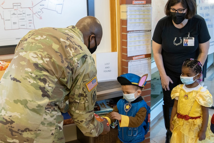 Command Sgt. Maj. Kenneth F. Law, U.S. Army Financial Management Command senior enlisted advisor, gives treat bags to costumed students at a local daycare facility next to the Maj. Gen. Emmett J. Bean Federal Center Oct. 29, 2021. Law, along with Col. Paige M. Jennings, USAFMCOM commander, and Barry W. Hoffman, USAFMCOM deputy to the commander, delivered 100 festive treat bags to students at the center. (U.S. Army photo by Mark R. W. Orders-Woempner)