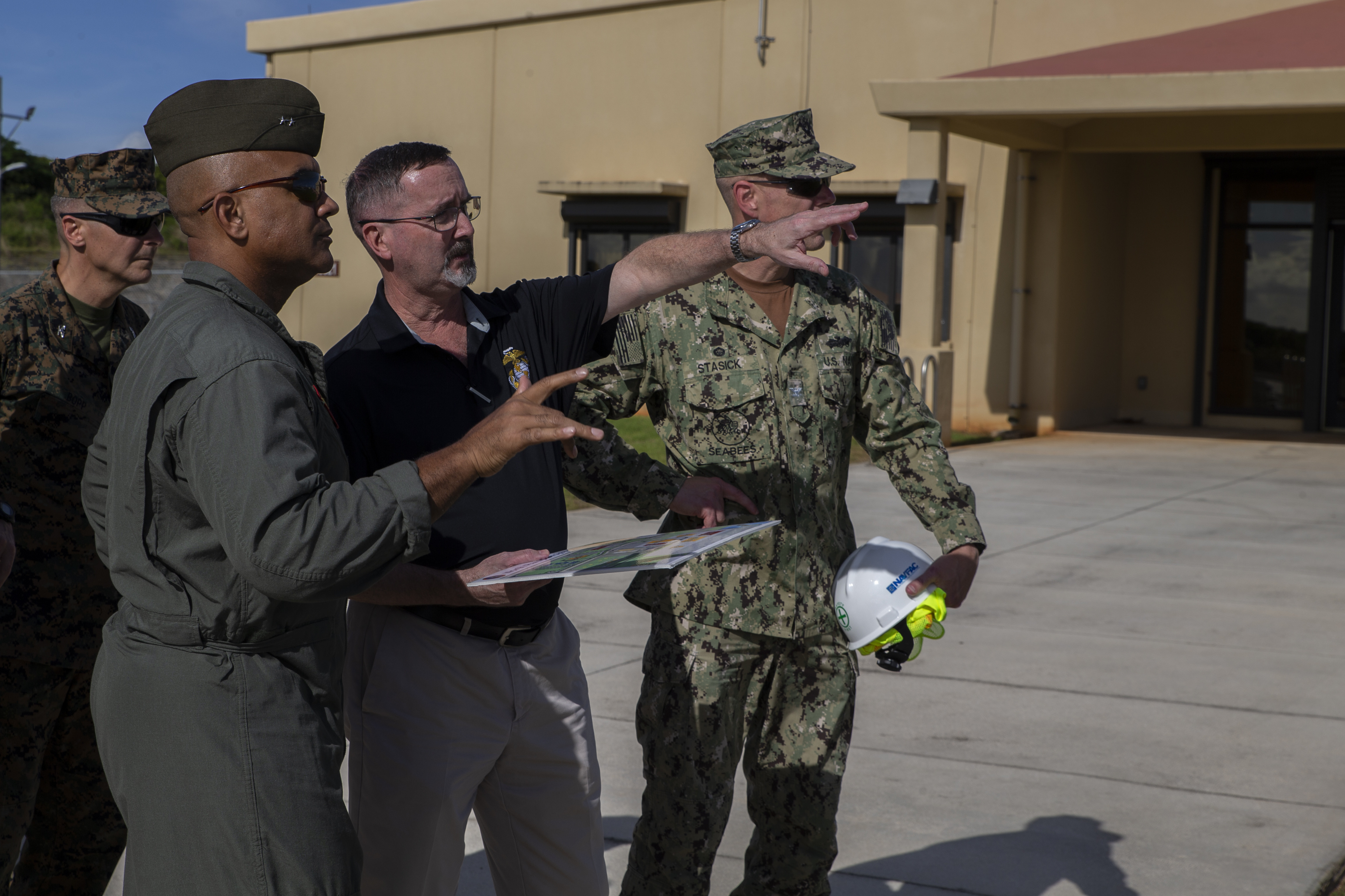 Donald Baldwin, the Marine Corps Base (MCB) Camp Blaz chief of staff, center, briefs U.S. Marine Corps Maj. Gen. Brian Cavanaugh, the 1st Marine Aircraft Wing commanding general, during a visit to a MCB Camp Blaz facility on Andersen Air Force Base, Oct. 27, 2021.