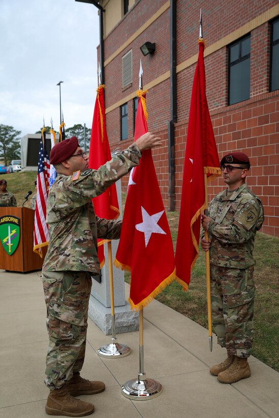 Sgt. 1st Class Alexander Duncan, noncommissioned officer in charge for the U.S. Army Civil Affairs and Psychological Operations Command (Airborne) Strategic Initiatives Group (SIG), inspects the new two-star flag for Maj. Gen. Jeffrey C. Coggin, commanding general, USACAPOC(A), during the promotion ceremony held Oct. 25, 2021, Fort Bragg, N.C.