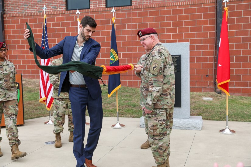 Kevin Coggin, son of Maj. Gen. Jeffrey C. Coggin, commanding general, U.S. Army Civil Affairs and Psychological Operations Command (Airborne), uncases his father’s new two-star flag during the latter’s promotion ceremony, Oct. 25, 2021, Fort Bragg, N.C.