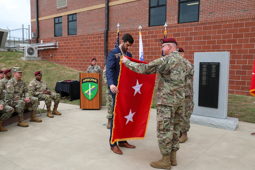Kevin Coggin, son of Maj. Gen. Jeffrey C. Coggin, commanding general, U.S. Army Civil Affairs and Psychological Operations Command (Airborne), inspects his father’s new two-star flag during the latter’s promotion ceremony, Oct. 25, 2021, Fort Bragg, N.C.