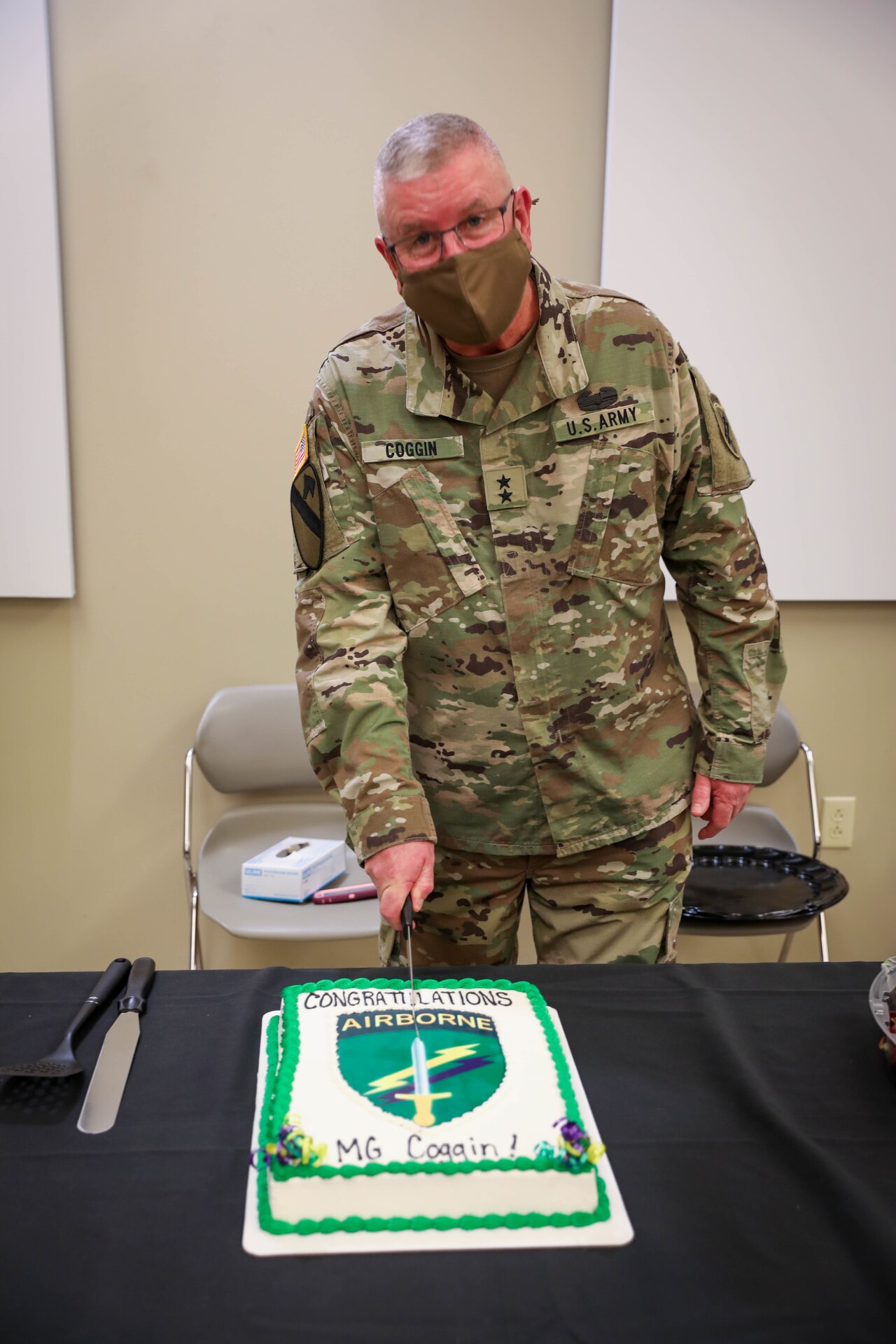 Maj. Gen. Jeffrey C. Coggin, commanding general, U.S. Army Civil Affairs and Psychological Operations Command (Airborne), makes the ceremonial first cut of his cake during the reception portion of his promotion ceremony, held Oct. 25, 2021, Fort Bragg, N.C.