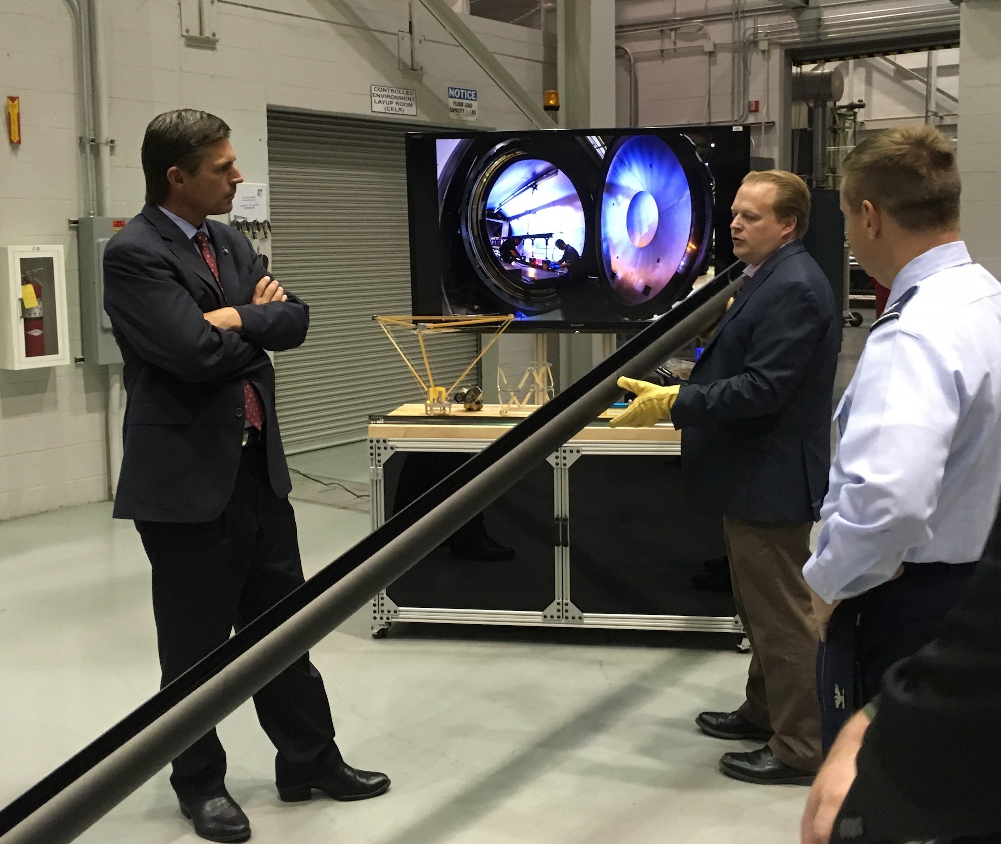 Dr. Andy Williams, center, Air Force Research Laboratory Deputy Technology Executive Officer for Space Science & Technology, explains the engineering of the Roll-Out-Solar Array, or ROSA, to U.S. Senator Martin Heinrich during a past visit to AFRL’s Space Vehicles Directorate at Kirtland Air Force Base, New Mexico. (Courtesy photo)