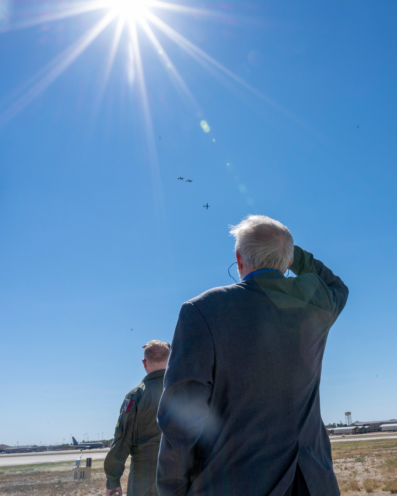 An Air Education and Training Command civic leader looks up at a four-ship flight of T-6 "Texan II" trainer aircraft during a tour at Laughlin Air Force Base, Texas, Oct. 28, 2021. The AETC Civic Leader Group visit allows civic leaders to see an AETC base’s mission up close and learn more about how civilian leaders and military members can work together. (U.S. Air Force photo by Senior Airman Nicholas Larsen)