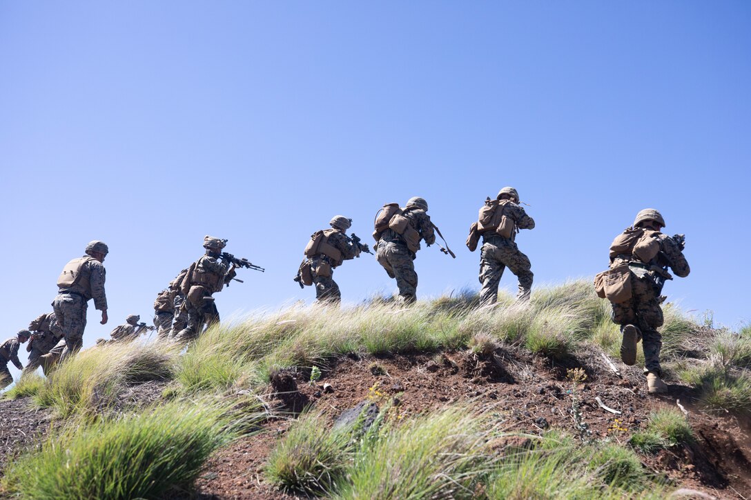 U.S. Marines with Kilo Company, 3d Battalion, 3d Marines, move over a hill during Bougainville II at Pohakuloa Training Area, Hawaii, Oct. 7, 2021. Bougainville II is the second phase of pre-deployment training conducted by the battalion designed to increase combat readiness through complex and realistic live-fire training. (U.S. Marine Corps photo by Cpl. Brandon Aultman)