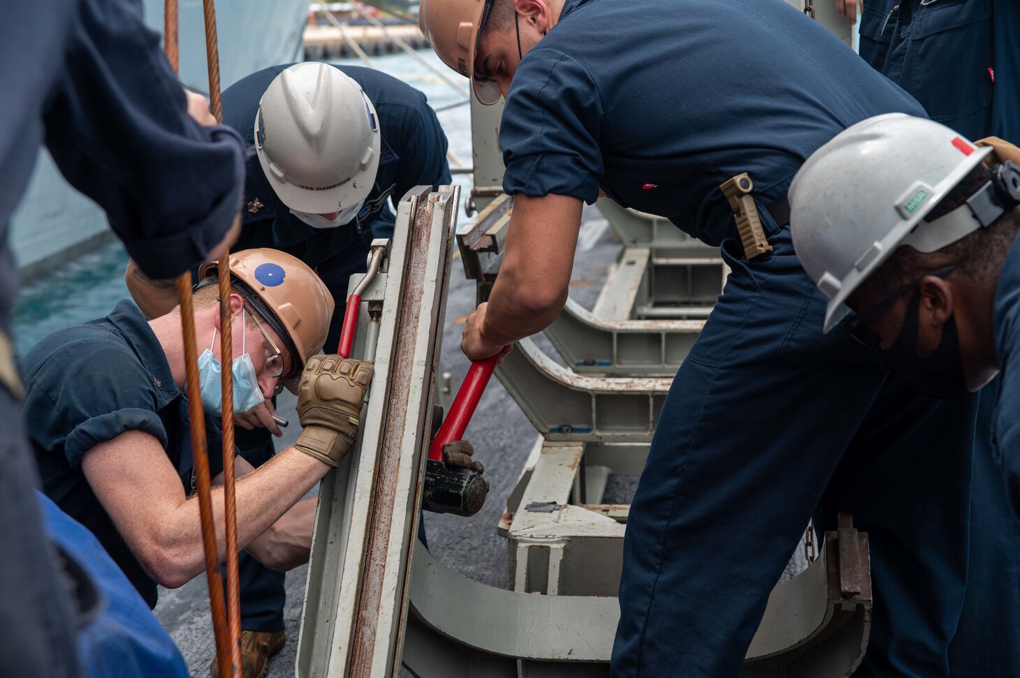 SAIPAN (Oct. 22, 2021) Torpedoman’s Mate 3rd Class Kyle Taylor of Belleville, New Jersey, left, assembles a deck skid used for loading torpedoes aboard the Los Angeles-class fast attack submarine USS Hampton (SSN 767) at the island of Saipan, Commonwealth of the Northern Mariana Islands, Oct. 22. Hampton is alongside the submarine tender USS Frank Cable (AS 40) for a weapons handling exercise involving the transfer of a MK-48 inert training shape. Frank Cable is on patrol conducting expeditionary maintenance and logistics in support of national security in the 7th Fleet area of operations. (U.S. Navy photo by Mass Communication Specialist 1st Class Charlotte C. Oliver)