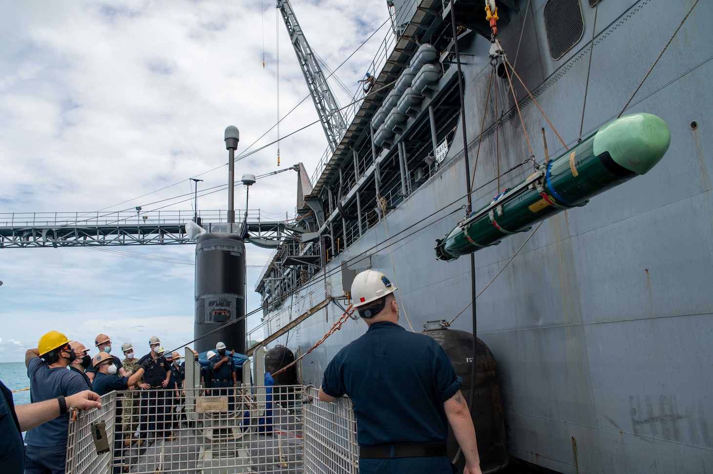 SAIPAN (Oct. 22, 2021) Sailors assigned to the Los Angeles-class fast attack submarine USS Hampton (SSN 767) guide a MK-48 inert training shape to the deck skid during a weapons handling exercise alongside the submarine tender USS Frank Cable (AS 40) at the island of Saipan, Commonwealth of the Northern Mariana Islands, Oct. 22. Frank Cable is on patrol conducting expeditionary maintenance and logistics in support of national security in the 7th Fleet area of operations. (U.S. Navy photo by Mass Communication Specialist 1st Class Charlotte C. Oliver)