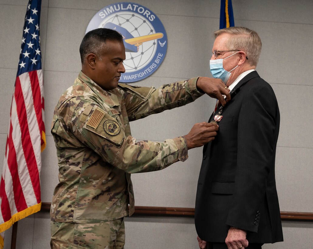 The Agile Combat Support Directorate's Simulators Division director, Col. John Kurian (left), presents his deputy director, John Carr, the Outstanding Civilian Career  Service Award during Carr's retirement ceremony on Wright-Patterson Air Force Base, Ohio, Oct. 29, 2021.