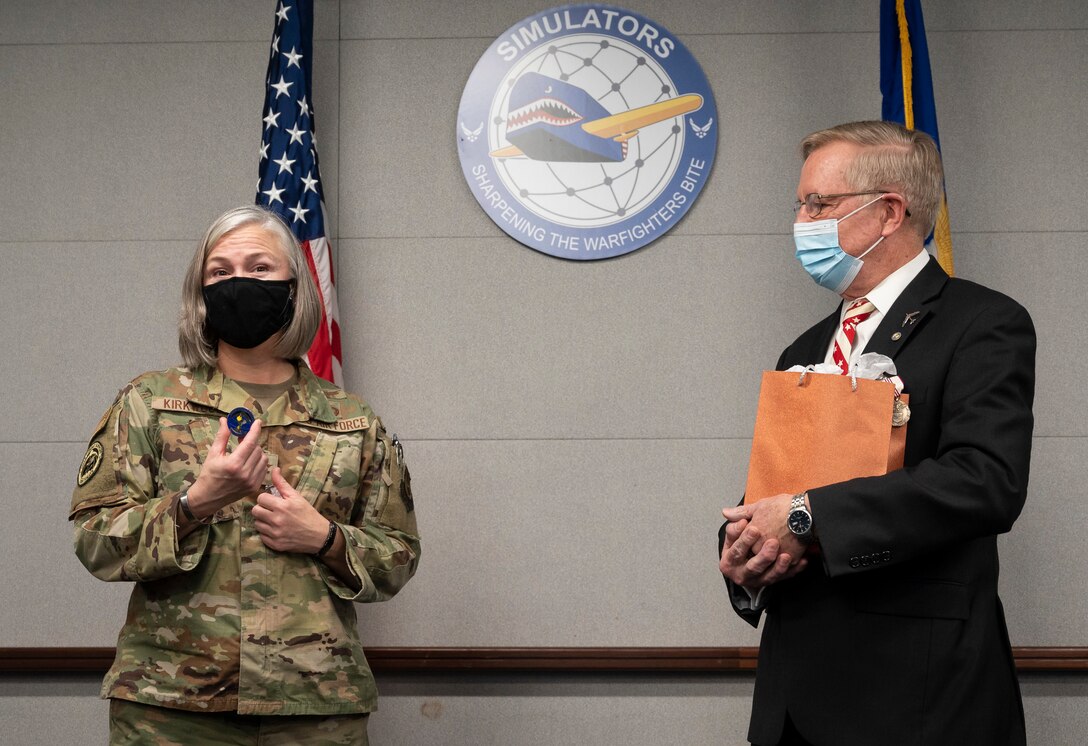 Col.  Lea Kirkwood, Director of the Agile Combat Support Directorate (left) presents a directorate coin to John Carr for his contributions as the deputy director of the directorate's Simulators Division.