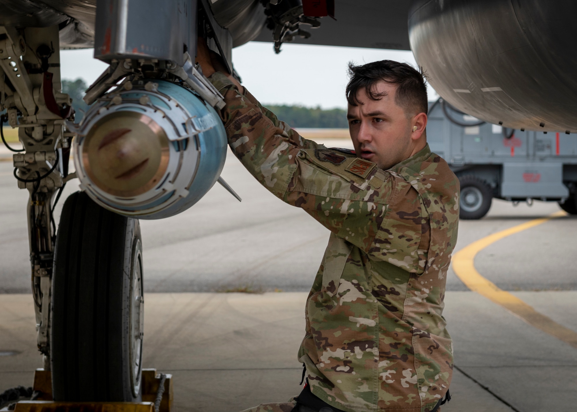 A load crew team chief connects a 1760 smart weapons cable to the GBU-38 during a quarterly load crew competition at Seymour Johnson Air Force Base, North Carolina, Oct. 21, 2021.