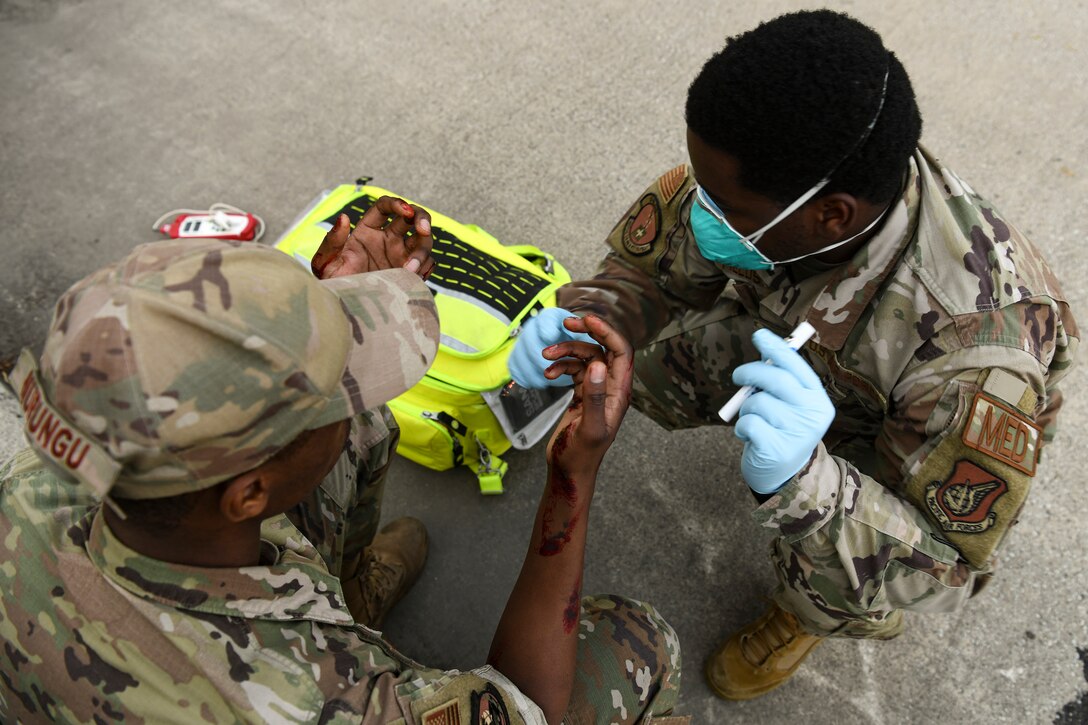 Staff Sgt. Averyous Fields, 8th Medical Group medical technician, provides medical care to Senior Airman Samuel Murungu, 8th Logistics Readiness Squadron vehicle maintenance technician, during routine training at Kunsan Air Base, Republic of Korea, Nov. 1, 2021. The 8th Medical Group supports the 8th Fighter Wing, Kunsan AB, and comprises the 8th Healthcare Operations Squadron (HCOS) and 8th Operational Medical Readiness Squadron (OMRS). This support is executed by delivering preventive health services and outpatient medical care to over 2,800 base personnel. (U.S. Air Force photo by Staff Sgt. Jesenia Landaverde)