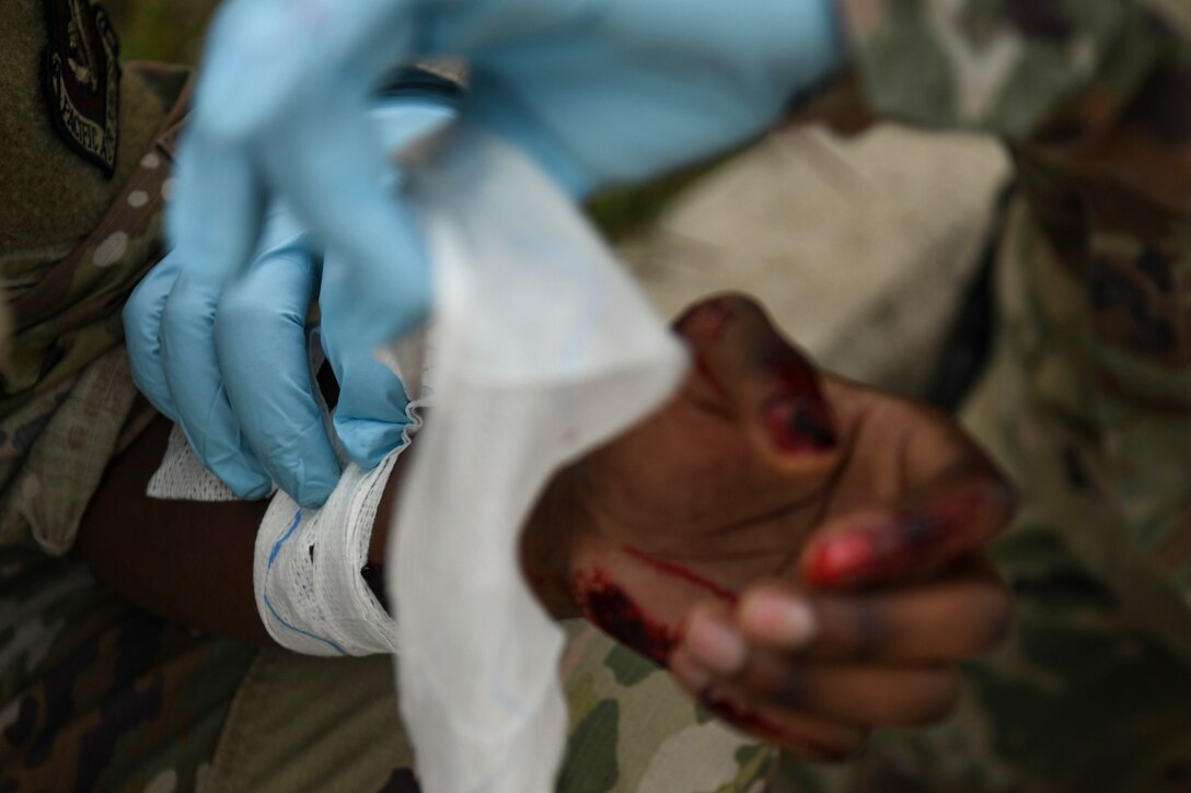 Senior Airman Samuel Murungu, 8th Logistics Readiness Squadron vehicle maintenance technician and simulated victim, receives medical treatment during routine training at Kunsan Air Base, Republic of Korea, Nov. 1, 2021. The main priority for the Kunsan AB first responders, including the 8th Civil Engineer Squadron firefighters and 8th Medical Group medical technicians, is to relocate injured personnel to safety to receive further medical treatment. (U.S. Air Force photo by Staff Sgt. Jesenia Landaverde)