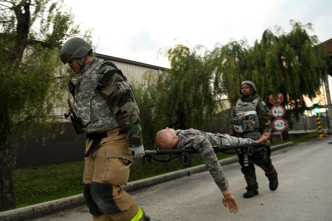 An 8th Civil Engineer Squadron firefighter and 8th Medical Group medical technician carry a simulated victim to safety during routine training at Kunsan Air Base, Republic of Korea, Nov. 1, 2021. The 8th Medical Group supports the 8th Fighter Wing, Kunsan AB, and comprises the 8th Healthcare Operations Squadron (HCOS) and 8th Operational Medical Readiness Squadron (OMRS). This support is executed by delivering preventive health services and outpatient medical care to over 2,800 base personnel. (U.S. Air Force photo by Staff Sgt. Jesenia Landaverde)