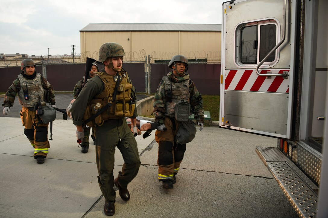 Two 8th Civil Engineer Squadron firefighters, a 8th Medical Group medical technician and a U.S. Marine first responders transfer a simulated victim to safety during routine training at Kunsan Air Base, Republic of Korea, Nov. 1, 2021. The main priority for the Kunsan AB first responders, including the 8th CES firefighters and 8th MDG medical technicians, is to relocate injured personnel to safety to receive further medical treatment. (U.S. Air Force photo by Staff Sgt. Jesenia Landaverde)