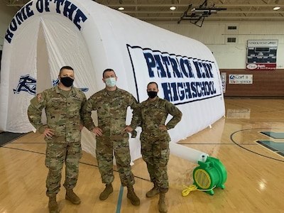 Virginia Army National Guard recruiters pose in front of a tunnel at Patrick Henry High School in Glade Spring, Virginia. Staff Sgt. Matthew Riley, center, coaches at the school and helped fund the tunnel by donating his full salary back to the school. (Courtesy photo)