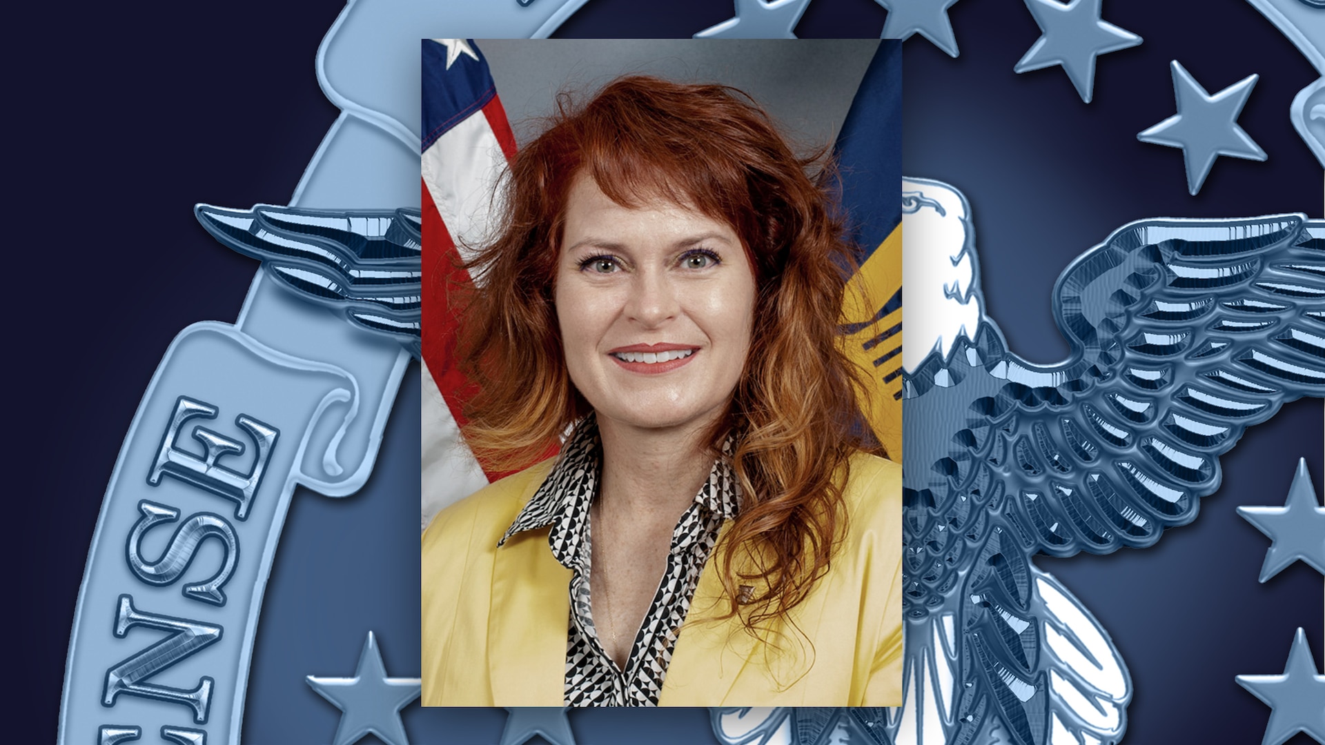 White woman with red hair and yellow jacket poses for a head/shoulders photo in front of the US flag.
