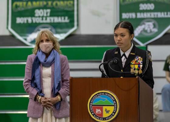 First Lady Dr. Jill Biden, left, is introduced by Cadet Lt. Cmdr. Jazlyn Ballman during a pep rally at the school gym onboard Naval Support Activity (NSA) Naples, Italy, Nov. 1, 2021.