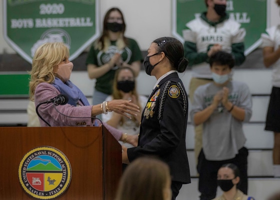 First Lady Dr. Jill Biden, left, thanks Cadet Lt. Cmdr. Jazlyn Ballman for the introduction before speaking at the school gym onboard Naval Support Activity (NSA) Naples, Italy, Nov. 1, 2021.