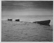 "Coast Guardsmen from the cutter SPENCER picking up survivors from the Nazi U-Boat just before it made its final dive.  Meanwhile the convoy steamed on."