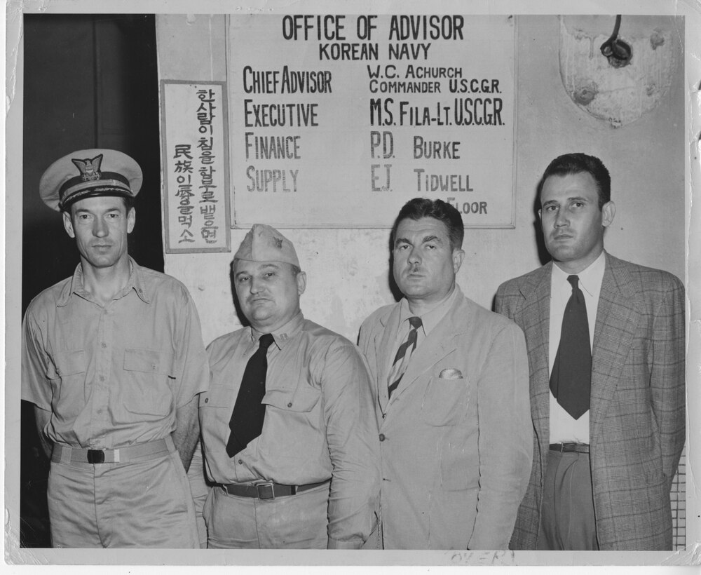 Members of the U.S. Military Advisory Group to the Republic of Korea Station with the Korean Navy Headquarters Shown Left to Right: Commander William C. Achurch, USCGR, Charleston, S.C.; Lieutenant M. S. Fila, USCGR, St. Louis, MO.; Mr. Paul D. Burke, Bereley [sic] Calif.; Mr. Freddie Tidwell, Lizella, G