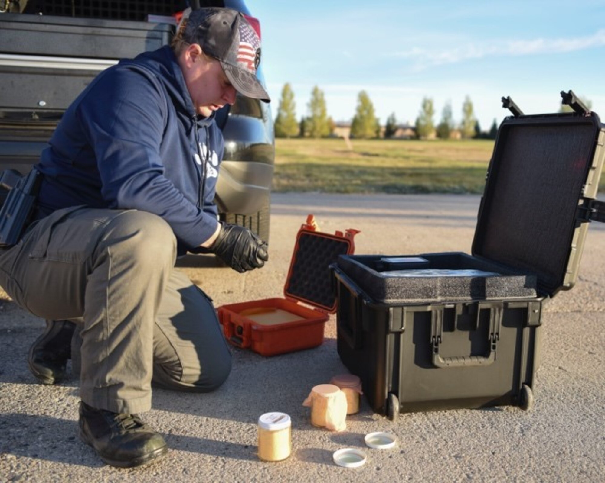 An officer prepares explosive odors for the military working dog training.