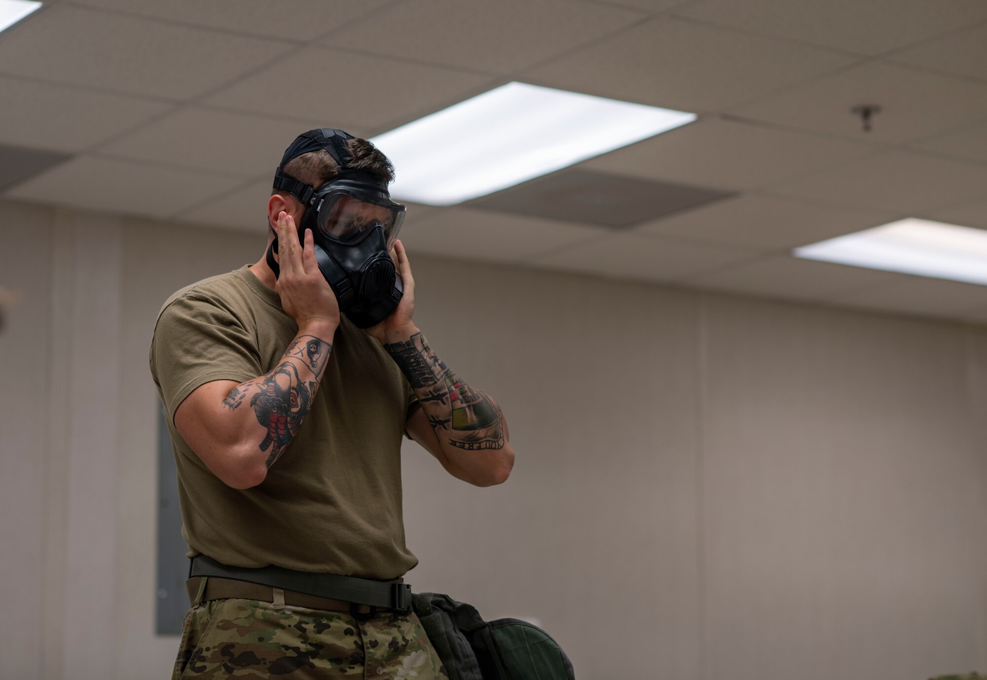 Man checks the seal on his gasmask