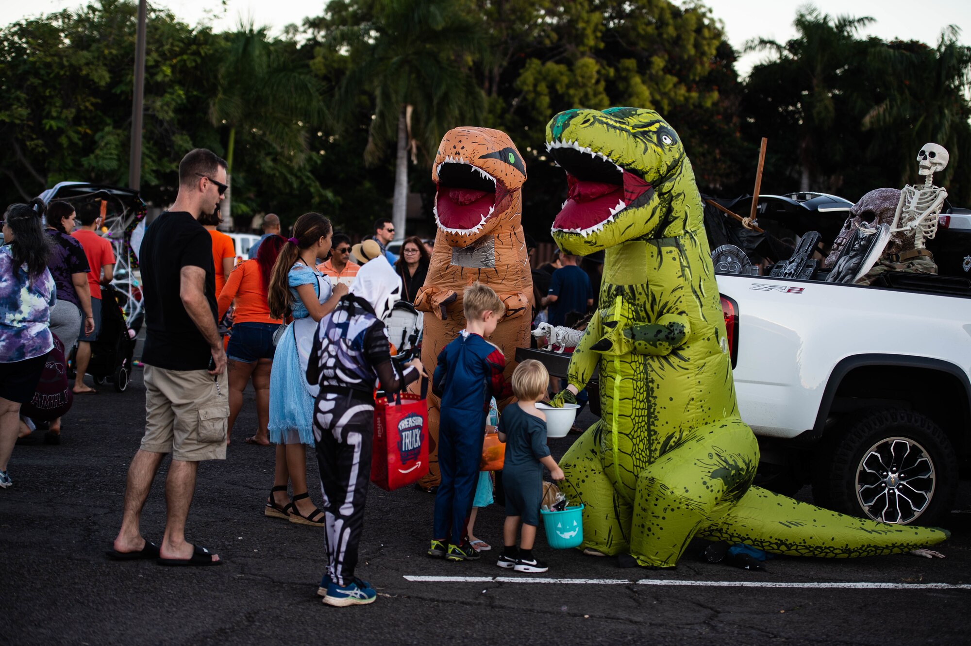 Trick-or-treaters visit several decorated vehicles for Halloween candy during “The Trunk of Treats” event at Joint Base Pearl Harbor-Hickam, Hawaii, Oct. 29, 2021. Trunk-or-Treat is an event that offers trick-or-treating down a row of decorated vehicles for families to walk through. (U.S. Air Force photo by Senior Airman Alan Ricker)