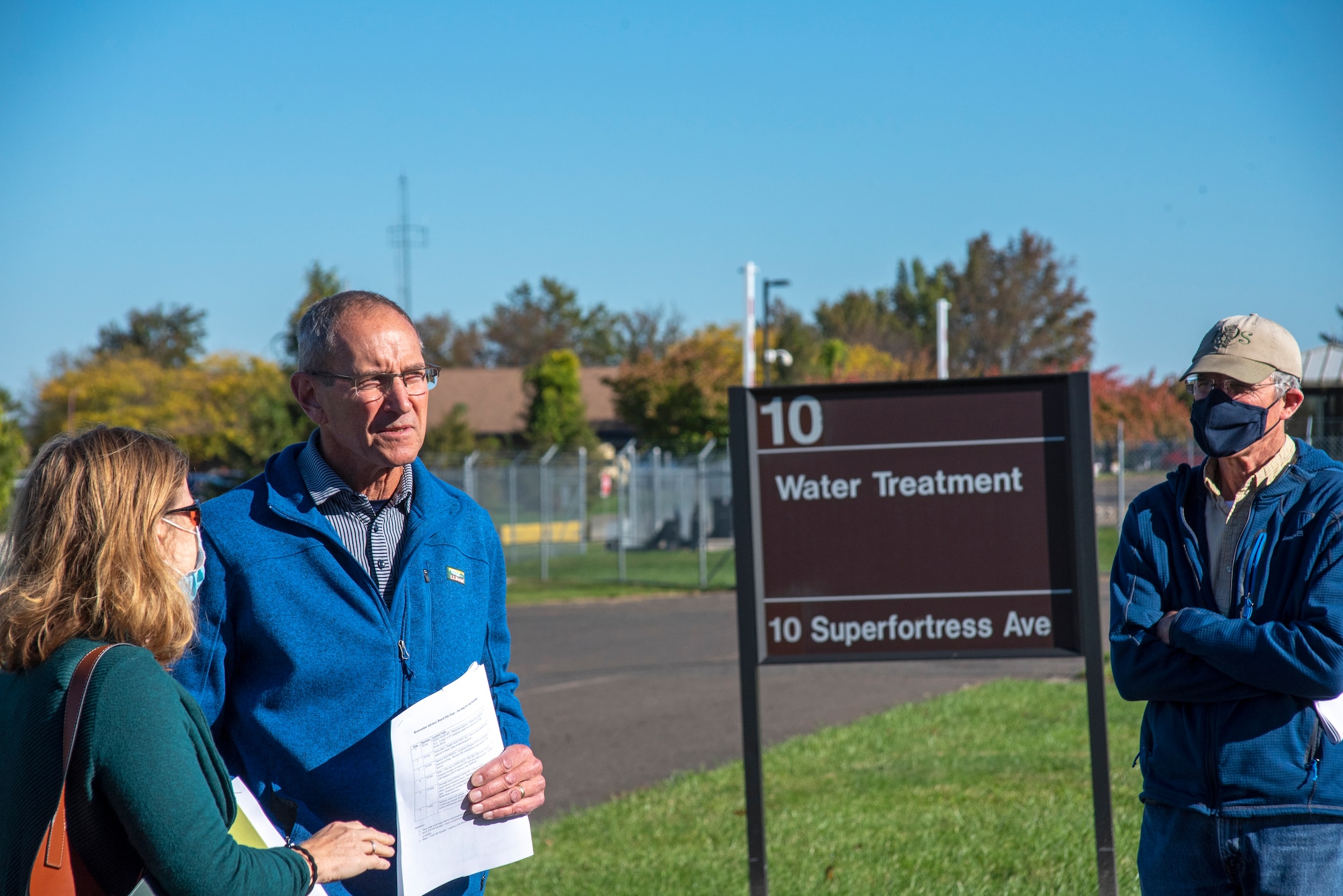 A man talks to a waman near a sign.