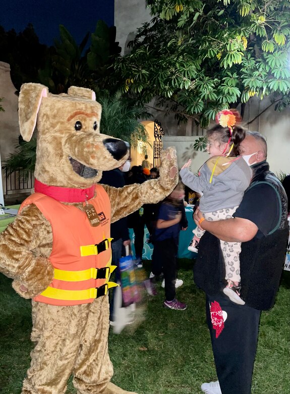 Paco Cervano and his granddaugher Una greet Bobber the Water Safety Dog during the Oct. 26 Día de los Muertos community event and procession at the LA River Center and Gardens in LA’s Cypress Park neighborhood. Hundreds of community members attended the event, which was organized by Mujeres de la Tierra, a nonprofit group whose mission is to “inspire, motivate and engage women and their children to take ownership and leadership of their neighborhood and local community issues.”