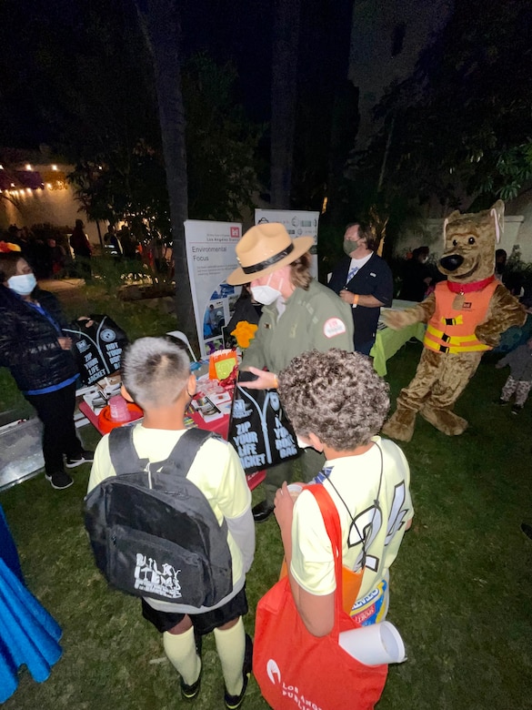LA District Park Ranger Linda Babcock provides free educational materials to young attendees of the Día de los Muertos community event and procession Oct. 26 at the LA River Center and Gardens in LA’s Cypress Park neighborhood.