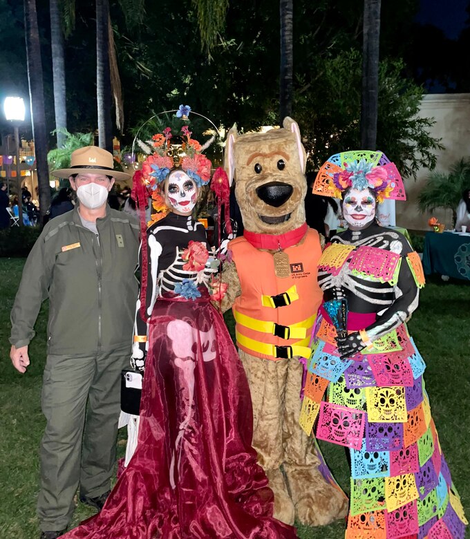 LA District Park Ranger Linda Babcock, left, and Ranger Annel Monsalvo as Bobber the Water Safety Dog, second from right, join Brittany Bautista, second from left, and her mother Rosa Bautista, for a photo at the Día de los Muertos community event and procession Oct. 26 at the LA River Center and Gardens in LA’s Cypress Park neighborhood.