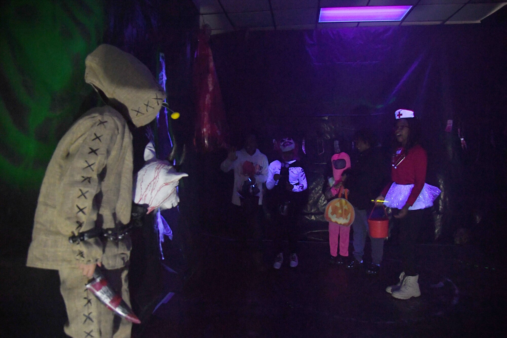 Keesler families walk through the haunted house during Ghouls in the Park at the marina park on Keesler Air Force Base, Mississippi, Oct. 29, 2021. The Halloween event also featured a hay ride, trunk-or-treat and various games for children of all ages. (U.S. Air Force photo by Kemberly Groue)
