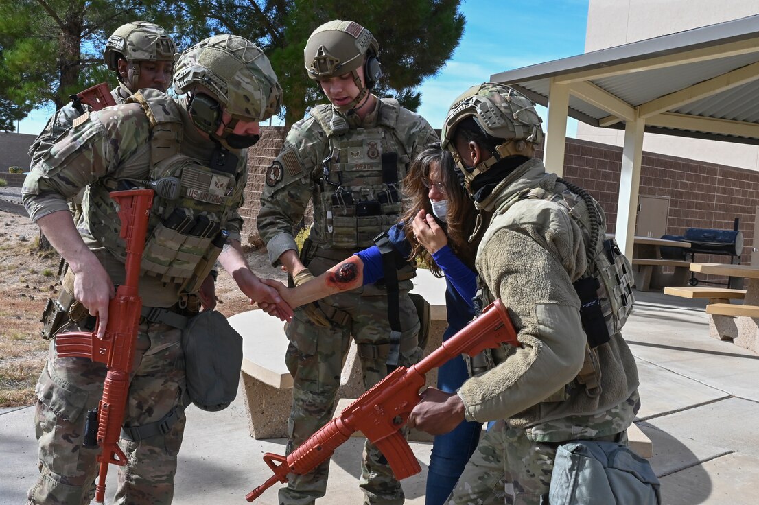 military security forces help a role player during an exercise