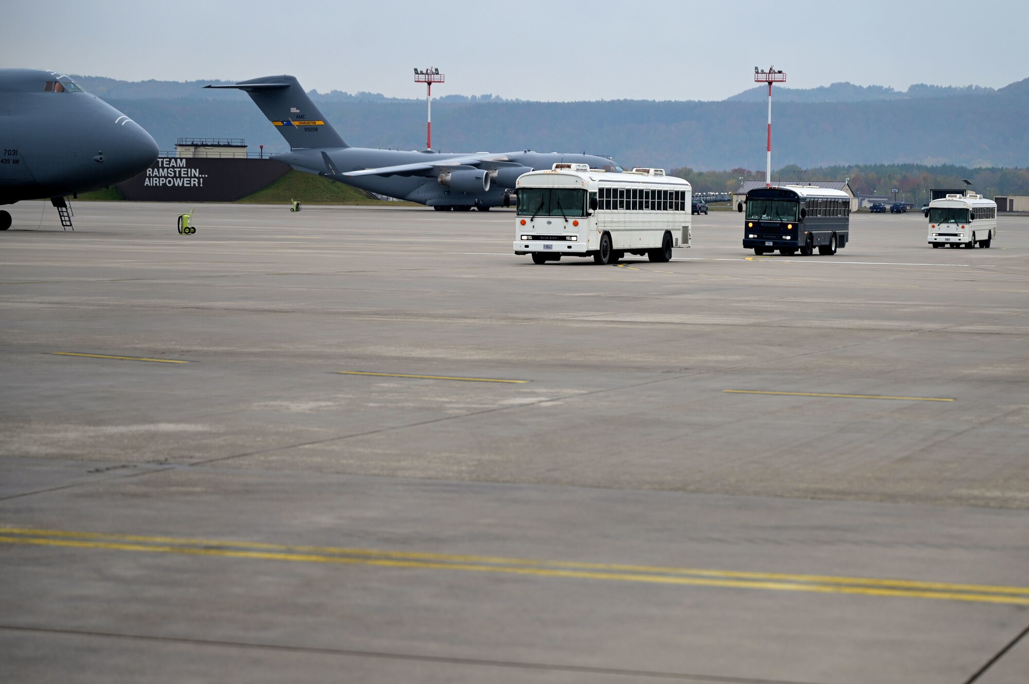 Three buses assigned to the 86th Vehicle Readiness Squadron transport evacuees from Afghanistan across the flightline to the final outbound flight to the United States from Ramstein Air Base, Germany, Oct. 30, 2021. Ramstein provided evacuees with temporary lodging, food, medical services and support while awaiting transportation to the U.S. and other transient locations.  (U.S. Air Force photo by Senior Airman Milton Hamilton)