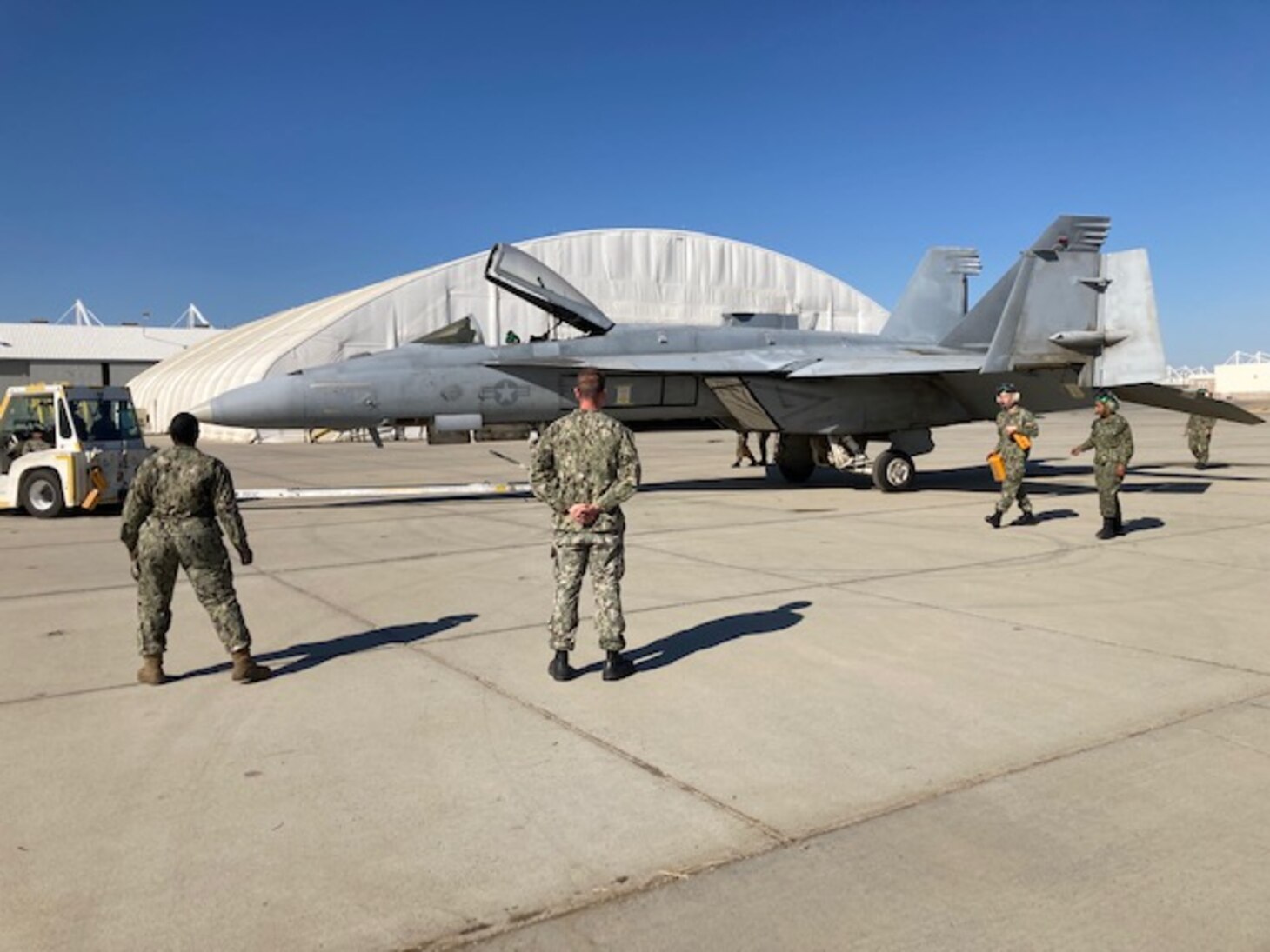 Aviation Machinist’s Mate 1st Class Shawn Marino (center) and Aviation Structural Mechanic 2nd Class Ashley McLean (left), assigned to Naval Aviation Maintenance Center for Excellence - Training (NAMCE-T) as subject matter experts, train Sailors from Strike Fighter Squadron (VFA) 136 “Knighthawks” as they tow an F/A-18E Super Hornet onboard Naval Air Station Lemoore, California, Oct. 14, 2021.