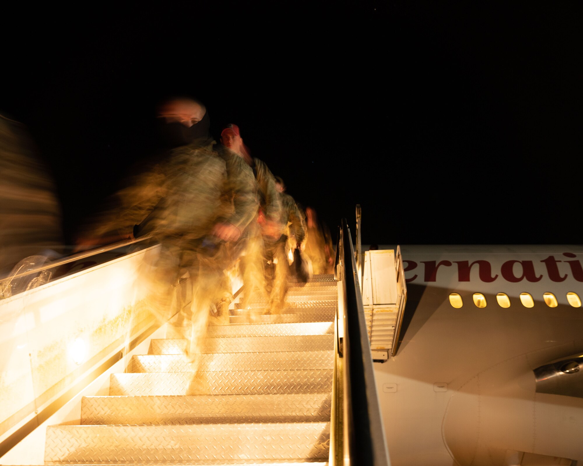 Airman from the 48th Fighter Wing disembark an aircraft after returning from deployment at Royal Air Force Lakenheath, England, Nov. 2, 2021. The 494th Fighter Squadron was deployed to an undisclosed location in Southwest Asia for eight months in support of Operation Inherent Resolve. (U.S. Air Force photo by Airman 1st Class Cedrique Oldaker)