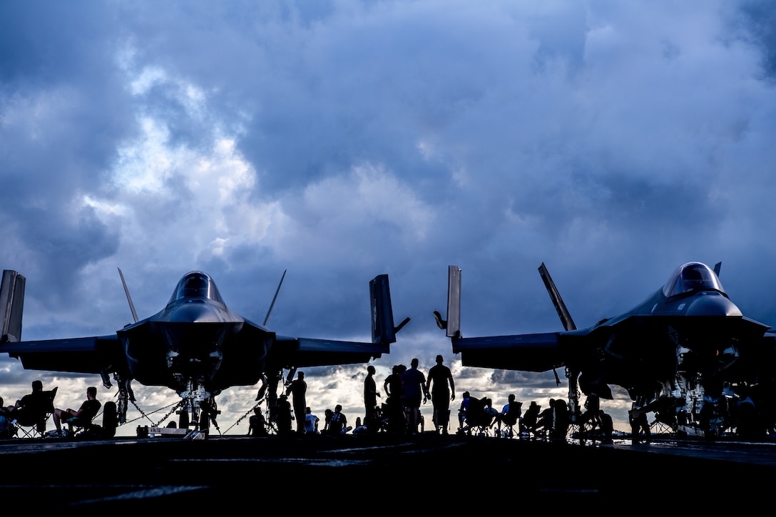 Sailors rest after physical training on the flight deck of Nimitz-class aircraft carrier USS Carl Vinson (CVN 70), Aug. 21, 2021.