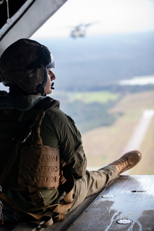 U.S. Marine Corps Sgt. Joseph Amenta, a crew chief with Marine Heavy Helicopter Squadron 772, Marine Aircraft Group 49, Marine Forces Reserve, observes a CH-53E Super Stallion while flying over Mississippi during exercise Raven 22-2, Oct. 24, 2021. Exercise Raven facilitated joint training with active and reserve component Marines, enabling a more capable and ready reserve force. (U.S. Marine Corps photo by Cpl. Brendan Mullin)