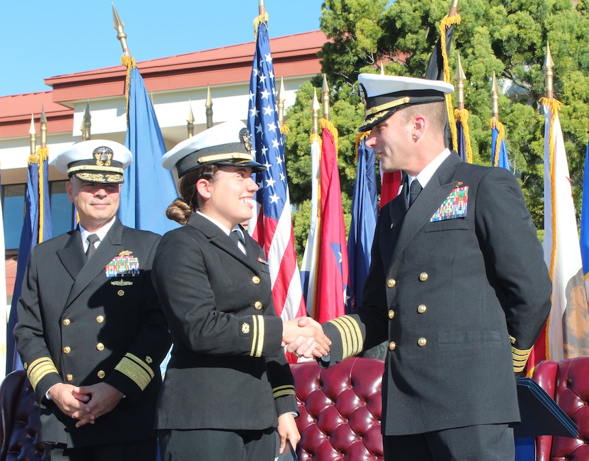 Lt. j.g. Lysabela Amaya, center, shakes hands with Capt. Peter Maculan, right, after receiving a certificate from Commander of Naval Facilities Engineering Systems Command and 45th Chief of Civil Engineers, Rear Adm. John W. Korka, left, during a graduation ceremony.  Amaya was one of 33 U.S. Navy Civil Engineer Corps (CEC) students who completed the 15-week-long CEC Basic Qualification Course at the Naval Civil Engineer Corps Officers School.