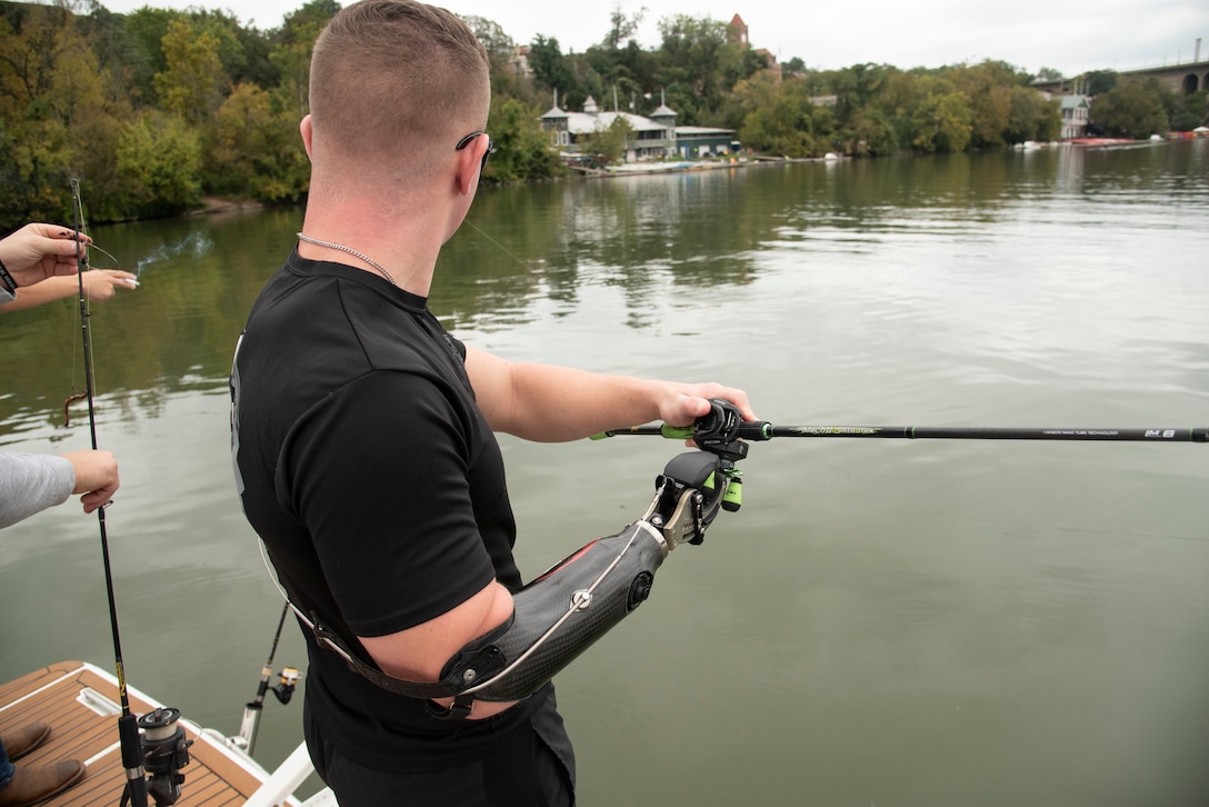 A recovering service member casts his line during a fishing trip on the Potomac River.