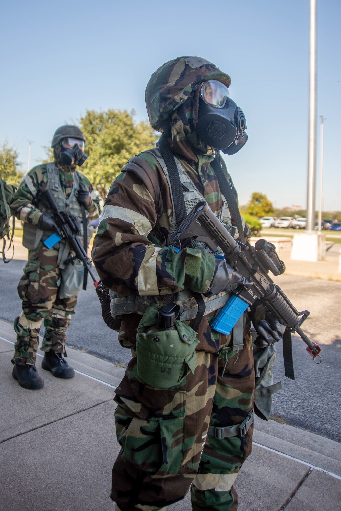 Airman stands in exercise gear with mock weapon