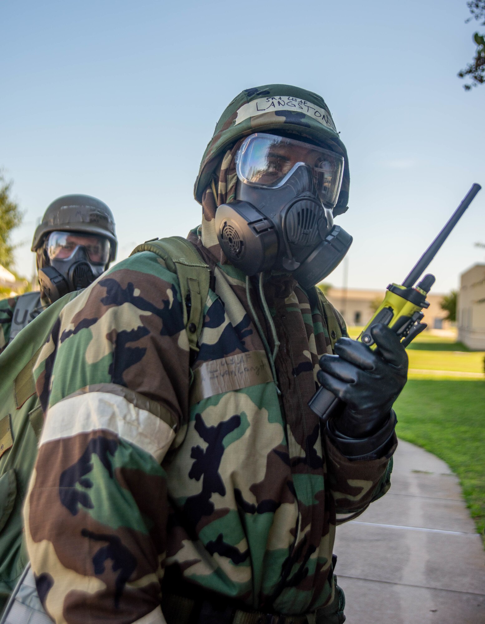 Airman in exercise gear talks on 2-way radio