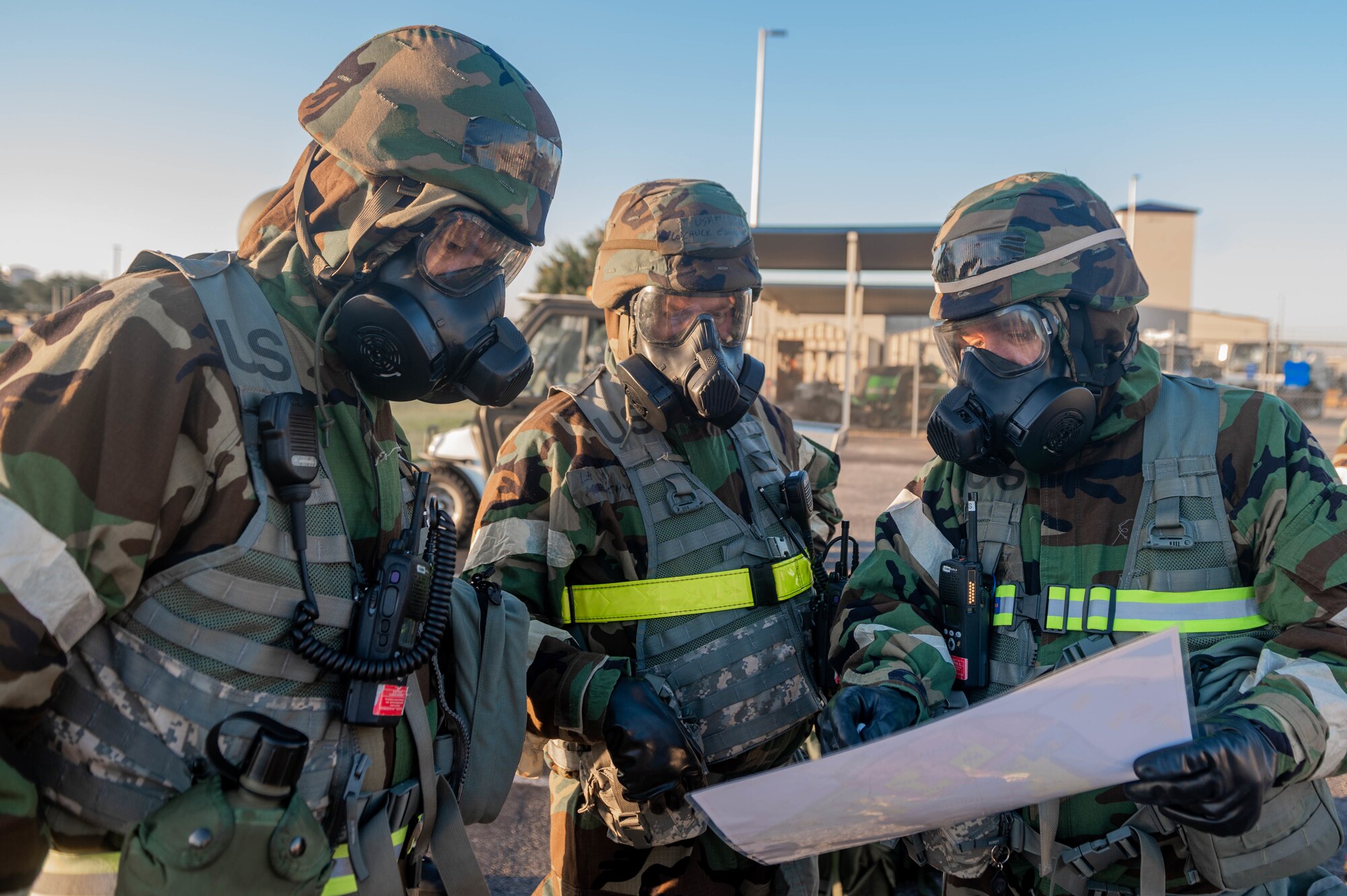 Airmen in exercise gear review a map