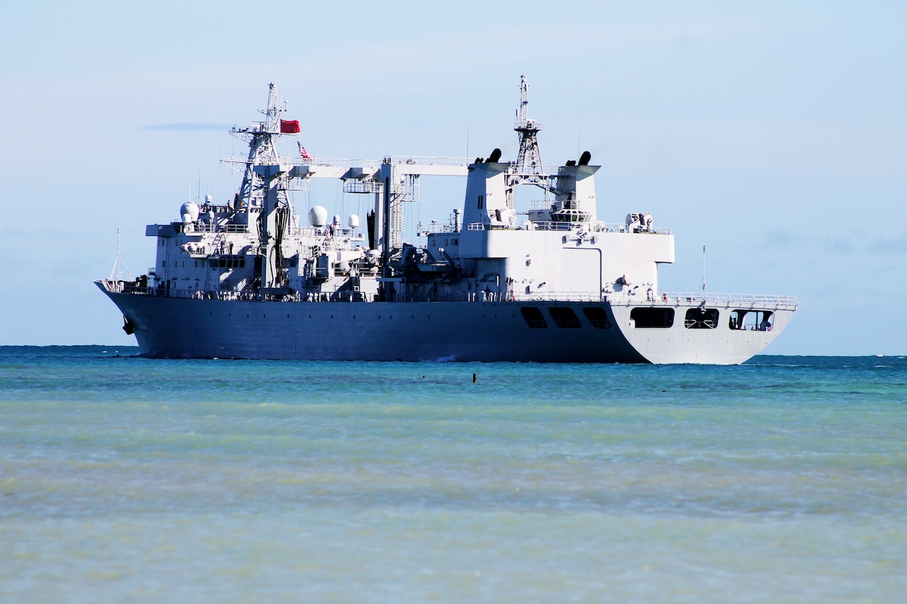 A large military vessel moves through the ocean.