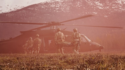 Alaska Air National Guardsmen assigned to the 212th Rescue Squadron, 176th Wing, transport patients to an Alaska Army National Guard UH-60L Black Hawk helicopter while conducting a full mission profile exercise at Joint Base Elmendorf-Richardson, Alaska, Oct. 13, 2021. The busiest rescue force in the Department of Defense, the 212th RQS provides elite pararescuemen and combat rescue officers that are uniquely skilled in integrating air and ground capabilities to carry out the 176th Wing’s wartime and peacetime personnel recovery missions. (U.S. Army National Guard photo by Dana Rosso)