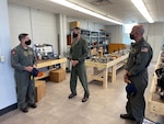 Rear Adm. F.R. “Lucky” Luchtman, NAVSAFECEN commander, receives a mission brief from Marine Corps Maj. Kyle Ladwig, Naval School of Aviation Safety (SAS) investigations instructor during a tour of the schoolhouse with SAS’s new commanding officer, Capt. Scott Janik. Janik became the school’s first commanding officer during a ceremony Oct. 19. (U.S. Navy photo by Cmdr. Zachary Miller)
